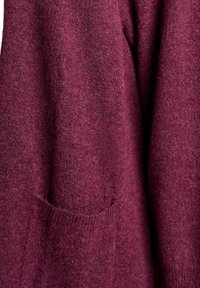 Burgundská pletená šatka s mäkkou textúrou a jednou prednou vreckom. Voľný strih s rebrovanými manžetami a lemom pre väčšie pohodlie.