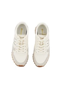 Sneakers atletici bianchi con accenti in suede grigio, design con lacci, suola in gomma testurizzata e un logo metallico sul lato.