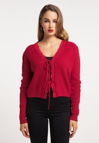Röd stickad cardigan med ett texturerat mönster, med en spetskantad V-ringning och knytband framtill, lång ärm och en kortad nederkant.