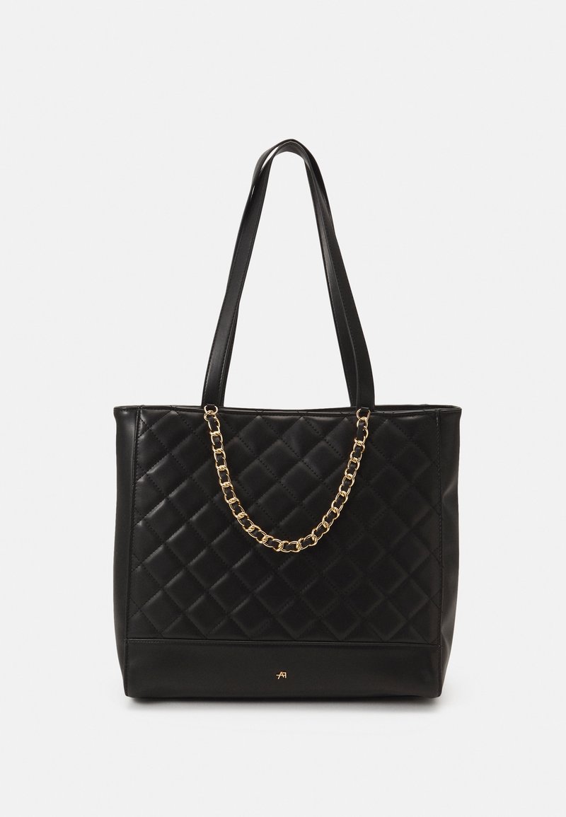 Bolso de tote acolchado negro con un brillante acento de cadena dorada. Hecho de suave piel sintética con dos resistentes correas para el hombro.