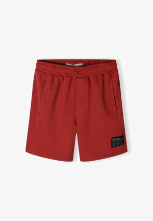 Røde sportsshorts lavet af blødt materiale, med elastisk talje, sidelommer og et syet mærke med sorte accenter.