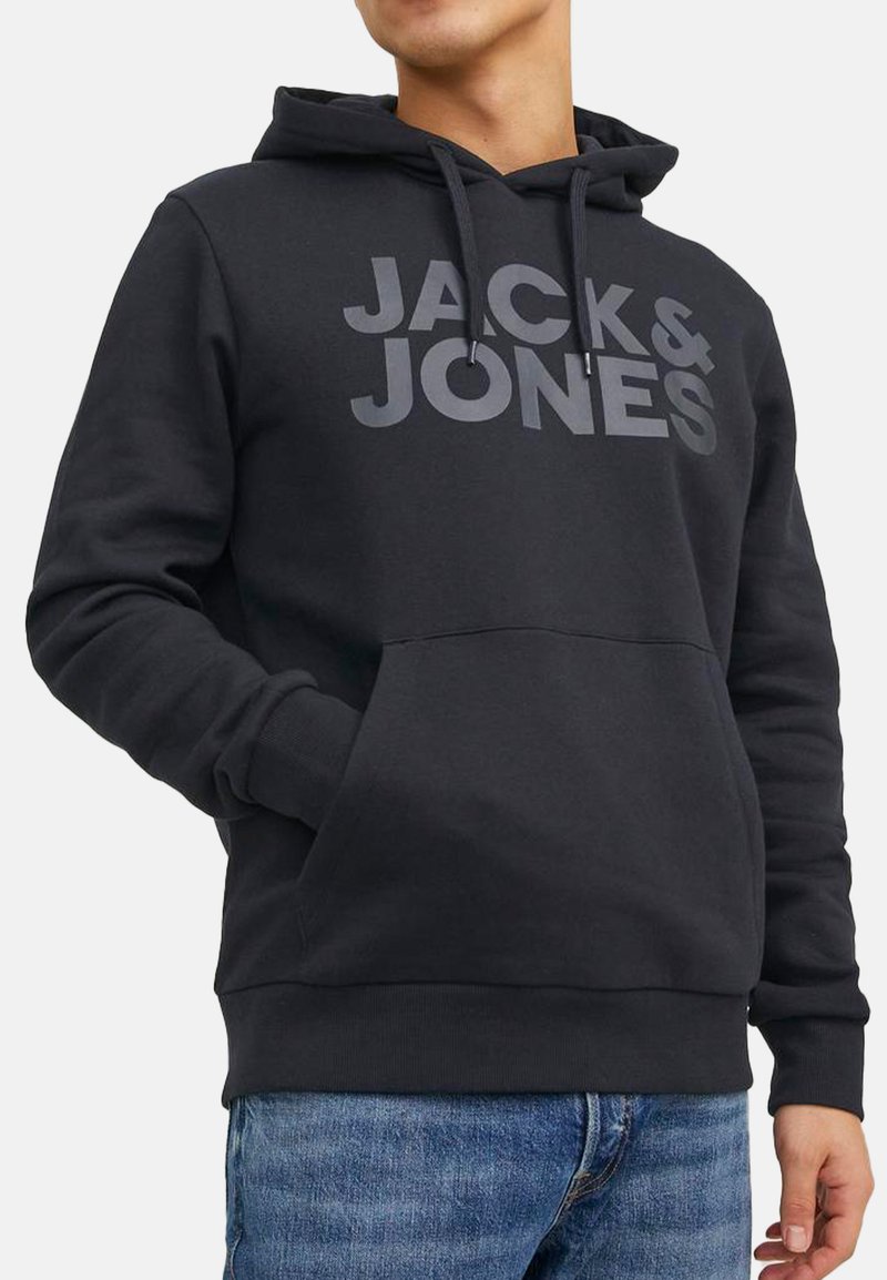 Uomo che indossa una felpa nera con cappuccio con il logo "JACK & JONES", tasca a marsupio frontale e jeans blu su uno sfondo semplice.