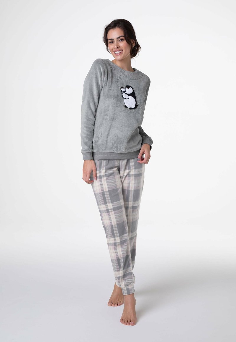 Felpa grigia in pile con applicazione a forma di pinguino; abbinata a pantaloni pigiama a quadri grigio chiaro. Texture morbida, vestibilità rilassata, bordi a costine.