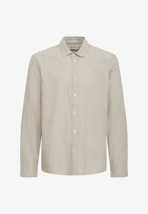 Chemise beige à manches longues avec col, boutonnée sur le devant, avec des boutons aux poignets et un tissu uni texturé.