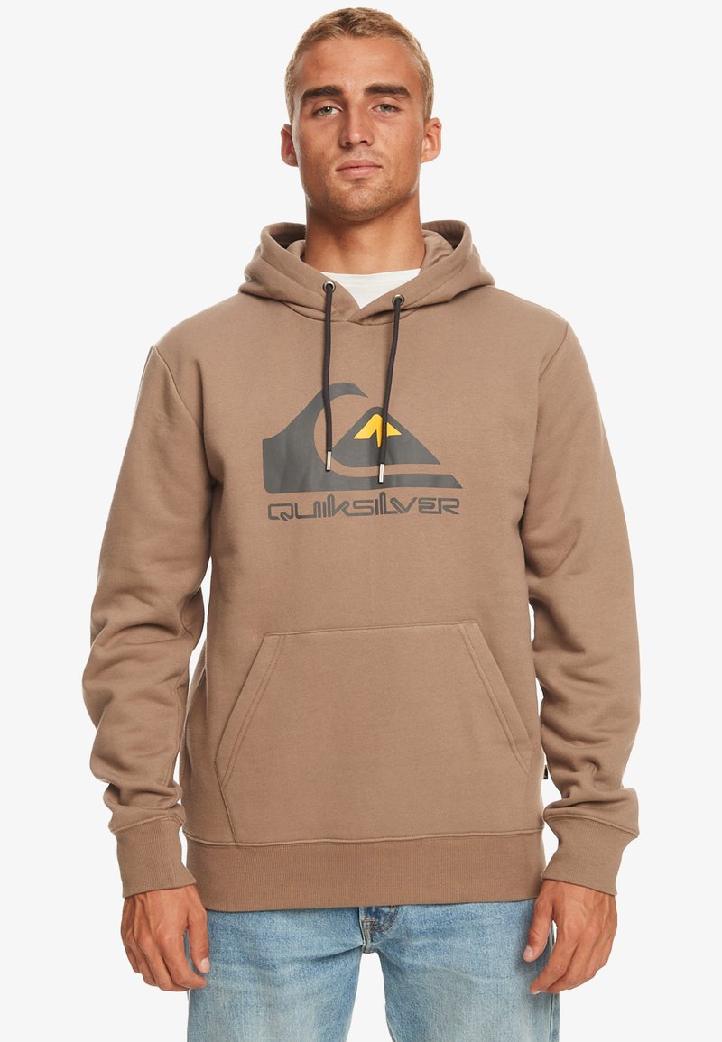 Brown pullover hoodie with a front kangaroo pocket, featuring a large Quiksilver logo in gray and yellow. Textured fabric and adjustable drawstring.