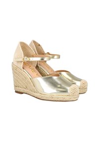 Espadrilles de cuña metálica dorada con parte superior de tela trenzada, punta cerrada y tira en el tobillo. El tacón envuelto en yute añade textura y altura.