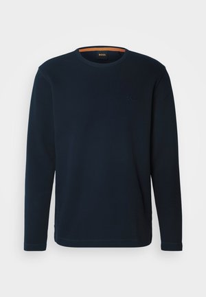 Navy long-sleeve T-shirt made of cotton blend, featuring a round neckline, ribbed texture, and subtle branding on the chest.
