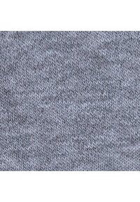 Tissu en tricot gris avec une texture chinée, présentant un motif de couture diagonal. Le matériau semble doux et extensible.