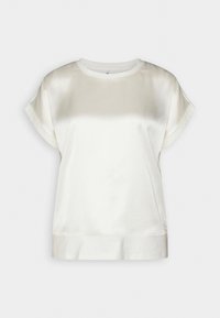 Haut en crème satinée avec un col bateau, des manches dolman courtes et une coupe ample. Texture lisse avec un léger éclat subtil.