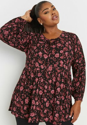 Túnica negra con flores que presenta mangas acampanadas, un cierre de botones y un diseño en capas con flores rosas. Tejido suave con una apariencia texturizada.