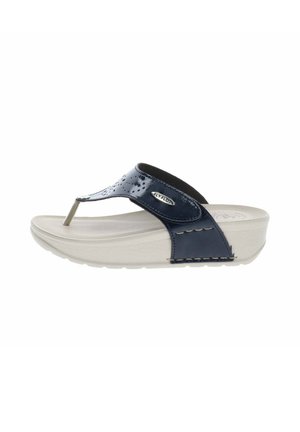 Sandalia tipo tanga de charol azul marino con suela de cuña acolchada beige y logo metálico FlyFlot en la tira lateral.