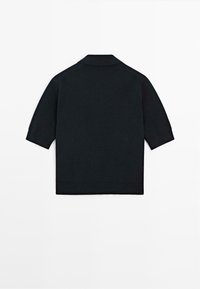 Polo shirt nero a maniche corte con colletto a coste e tessuto a maglia testurizzato. Presenta un orlo dritto e maniche raglan.
