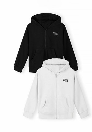 Dwie dziecięce bluzy na zamek, jedna czarna, druga biała, obie z przednimi kieszeniami i małym nadrukiem z tekstem na lewej piersi.