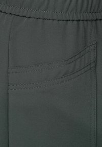 Tissu gris foncé avec ceinture élastique et détail de couture double au niveau de la couture incurvée de la poche latérale.