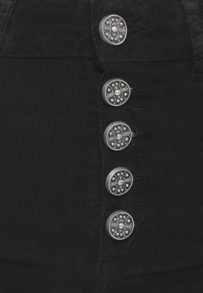 Tessuto in corduroy nero con cinque bottoni metallici che presentano un design circolare e dettagli decorativi lungo la parte anteriore.