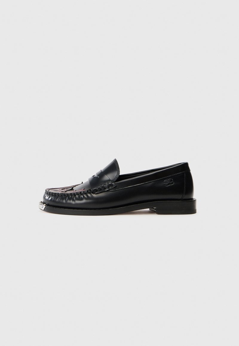 Zwarte leren loafers met een gemêleerde bovenkant, decoratieve stiksels en een lage blokhak. Kenmerkt een zilverkleurige accent bij de neus.