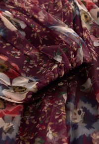 Caurspīdīgs violets audums ar ziedu rakstiem rozā, zaļā un krēmkrāsā. Savākti tekstūra ar maigu drapējumu un vieglu izskatu.