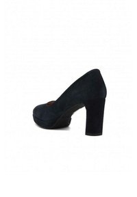 Scarpa con tacco alto in suede blu navy, con una piattaforma anteriore e un tacco spesso e strutturato. Texture liscia con design a punta arrotondata.