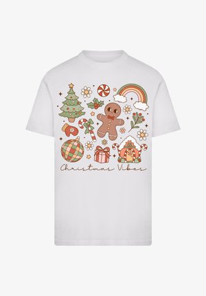 Weißes T-Shirt mit kurzen Ärmeln, das ein buntes Weihnachtsgrafikdesign zeigt, einschließlich eines Baumes, eines Lebkuchenmanns, Zuckerstangen und Geschenken.