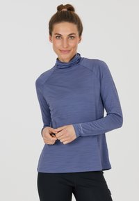 Langärmliges Oberteil mit Stehkragen aus heathered hellblauem Stoff, der eine glatte Textur und subtile Nähte aufweist. Es hat eine taillierte Silhouette und ein Markenlogo am Bündchen.