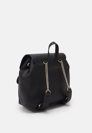 Black textured leather backpack with gold chain and leather straps, a top handle, and a flap closure.