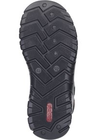 Black rubber shoe sole featuring a zigzag tread pattern for traction, with embossed brand logo and size indicator at the center.
