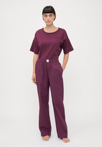 Paarse katoenen t-shirt met een ronde hals en korte mouwen, gecombineerd met een bijpassende loose-fit broek met een elastische tailleband en zijzakken.