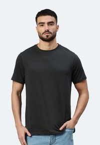 T-shirt nera a maniche corte realizzata in morbido cotone, con un design classico a girocollo e una vestibilità slim. Tessuto uniforme senza motivi o accenti.