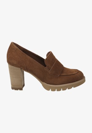 Brown suede heeled loafers with a wide strap across the vamp, textured rubber sole, and a chunky, ridged heel.