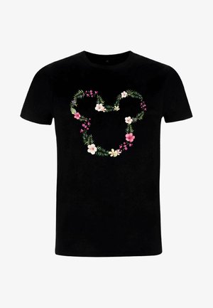 T-shirt en coton noir avec un motif floral en forme de cœur, comportant des fleurs roses et blanches ainsi que des feuilles vertes. Manches courtes et col rond.