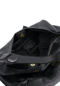 Zwarte leren handtas open met stoffen voering, voorzien van een ritsvak en magnetische sluiting.