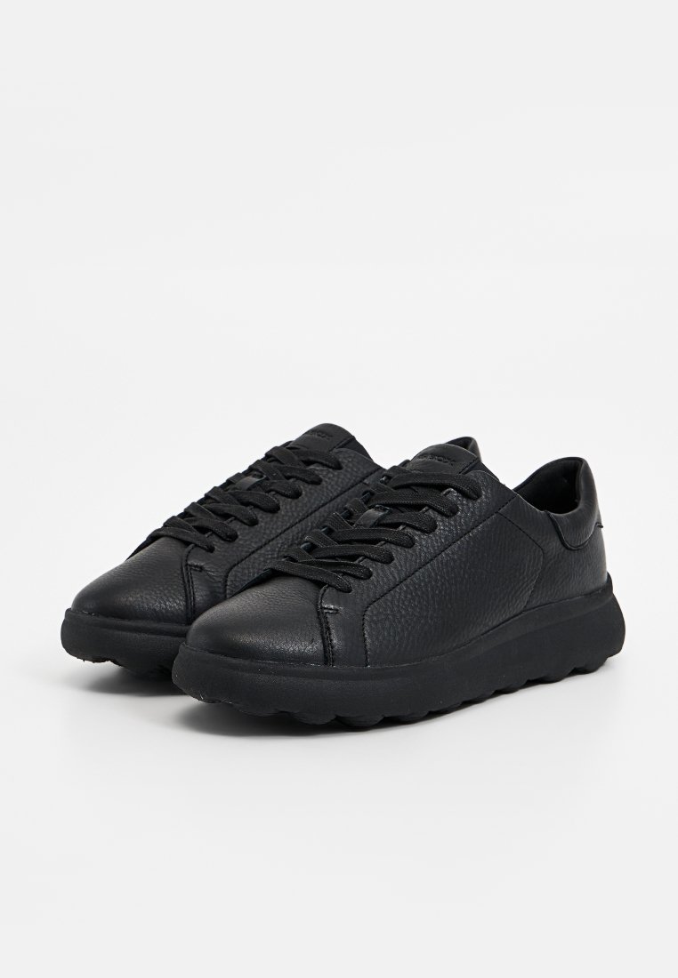 Schwarze Sneakers aus strukturiertem Leder mit runder Zehenpartie, sechs Ösen und einer robusten Gummisohle. Minimalistisches Design ohne sichtbare Logos.