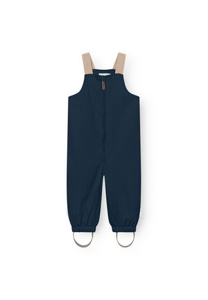 Marineblå vanntett overall med beige stropper, glidelås foran, elastiske mansjetter og sirkulære metalldetaljer ved ankler.
