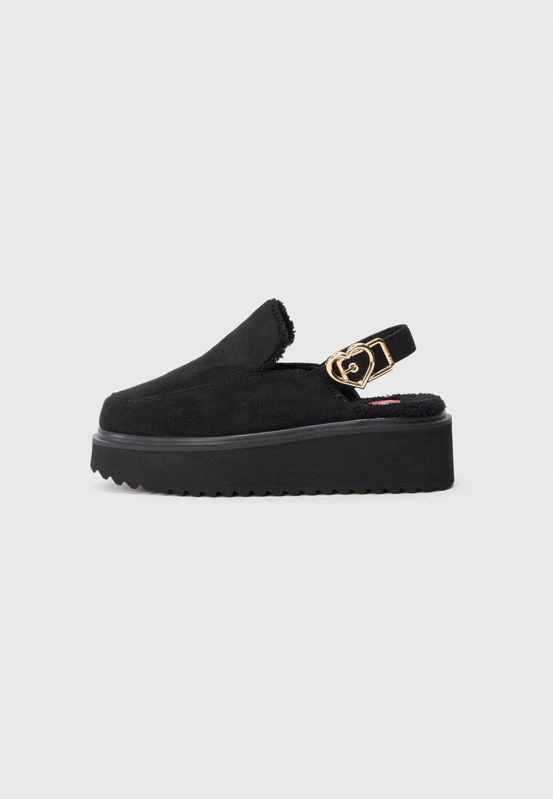Čierne platformové sandále so slingback dizajnom, jemným semišovým vrchom, hrubou gumovou podrážkou a zlatým detailom vo forme srdca na remienku.