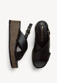 Sandali platform sintetici neri con cinturini incrociati, fibbia regolabile e texture intrecciata su una suola a strati. Taglia 37 indicata sulla soletta.