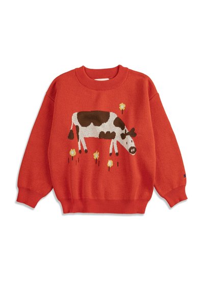 Pull en tricot rouge avec un motif de vache marron et blanc et de fleurs jaunes sur le devant, avec des poignets et un ourlet côtelés.