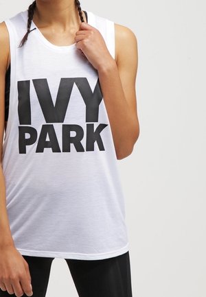 Biały, bezrękawnikowy top z odważnym, czarnym napisem 'IVY PARK', wykonany z miękkiego materiału, o luźnym kroju i zaokrąglonym dekolcie.