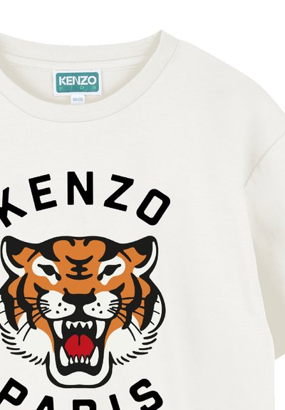 T-shirt en coton blanc présentant un grand visage de tigre graphique orange et noir, avec le texte « KENZO » et « PARIS » en noir gras.