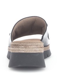 Černá kožená zadní část sandálu s akcentem z espadrilové šňůry a pevným černým gumovým podešví; viditelné měkké vnitřní polstrování.