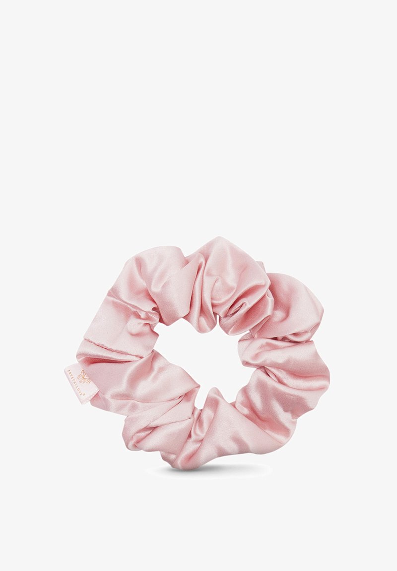 Scrunchie in satin rosa con una superficie liscia, caratterizzato da un design arricciato e un piccolo etichetta con il logo del marchio. Forma circolare per acconciare i capelli.