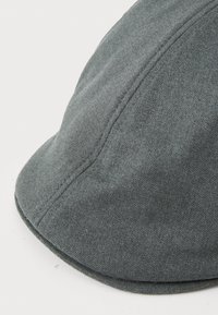 Casquette grise en tissu texturé avec une visière courbée, présentant des coutures nettes et une finition lisse. Pas de logos ni de motifs visibles.