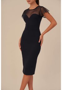 Mörkblå klänning med en figursydd silhuett, genomskinliga fladderärmar, hjärtformad halsringning och slät tyg, som slutar strax under knäet.