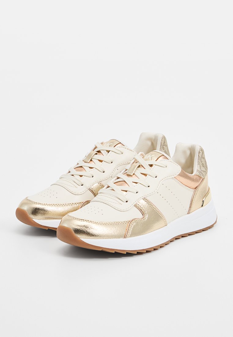 Baskets blanches et dorées avec une finition métallique lisse, un design à lacets, des détails perforés et une semelle en caoutchouc texturée.