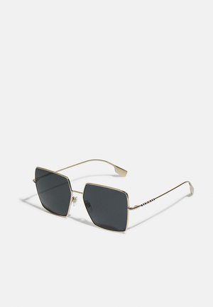 Ochelari de soare cu rame pătrate, lentile închise la culoare, accente din metal auriu și brațe subțiri decorate cu un model în dungi de roșu, negru și alb.