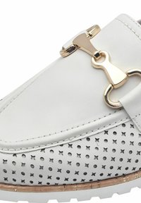 Weißes Leder-Schuhwerk mit durchlöchertem Seitendesign, goldenen Hardware-Akzenten, runder Zehenform und strukturiertem Laufsohle.