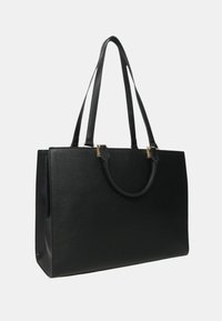 Borsa tote in pelle nera con una forma rettangolare strutturata, fondo piatto, lunghe tracolle e dettagli in hardware dorato.