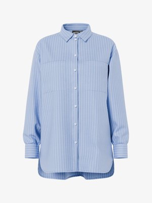 Světle modrá košile na knoflíky s bílými svislými pruhy. Má límec, dlouhé rukávy a dvě náprsní kapsy.
