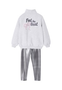 Gray sweatshirt with high collar, "Feel the Beat" text and bow graphic on back. Shiny silver leggings with a smooth texture.