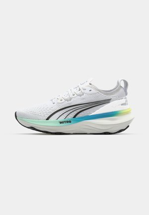 Scarpa da corsa bianca con upper in mesh testurizzato, dettagli neri e suola multicolore a gradiente con la parola "NITRO" sul lato.