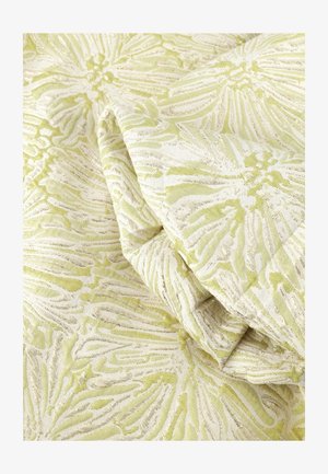 Tissu vert clair et crème plié, présentant des motifs floraux texturés avec des détails en relief et complexes.